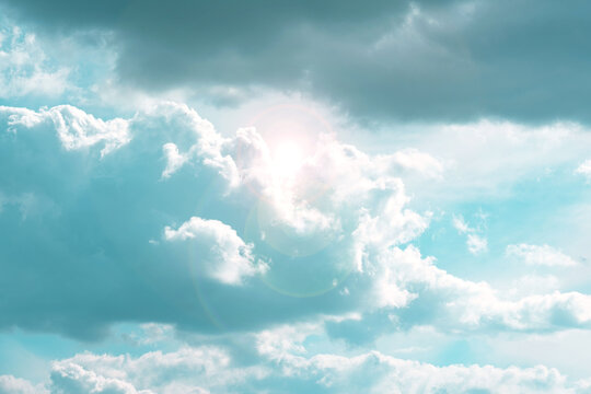 Sky.Clouds and sunshine. White clouds and sun rays in a light blue sky.Beautiful heavenly wallpaper in blue tones Heaven background.