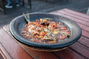 processed chili sauce made from tomatoes and chilies cooked with fresh fish on a clay plate, a typical food from Indonesia, Bontang, East Kalimantan, in Indonesian this food is called 