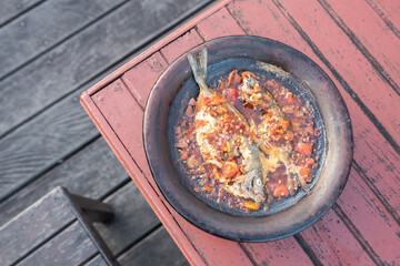 processed chili sauce made from tomatoes and chilies cooked with fresh fish on a clay plate, a typical food from Indonesia, Bontang, East Kalimantan, in Indonesian this food is called 