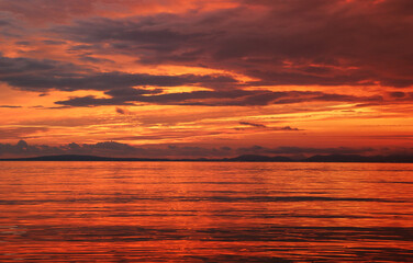 Relax atmosphere. Fiery sunset on the coast. View of the sunset on the sea, El Arenal, Mallorca. Bright saturated sunset on the sea and a rocking boat on the waves, Mallorca, Spain.