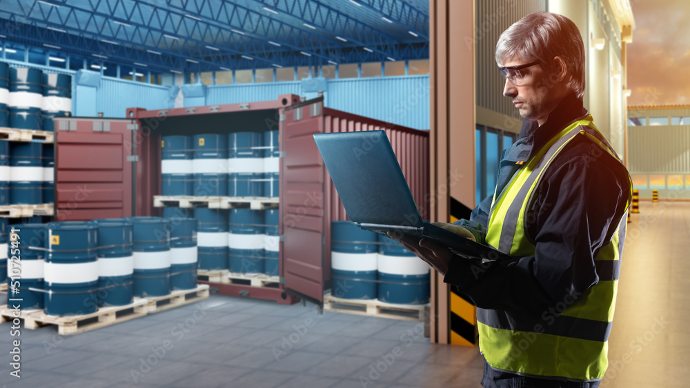 Wall mural oil logistics. man with laptop next to warehouse. blue barrels near container. sea container for tra