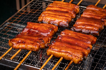 網で焼かれる鰻　eel	