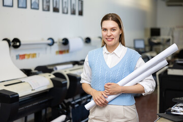 Portrait of positive woman with plotter roll paper in her hands