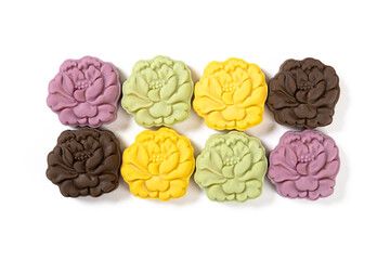 top view colorful flower shape snowy mooncakes on white