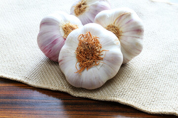 Closeup of portion of garlic bulb on the jute fabric.
