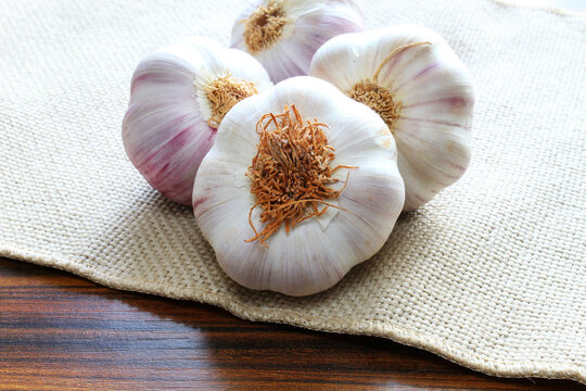 Closeup of portion of garlic bulb on the jute fabric.