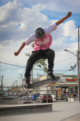 skater boy doing jump tricks in pink jersey