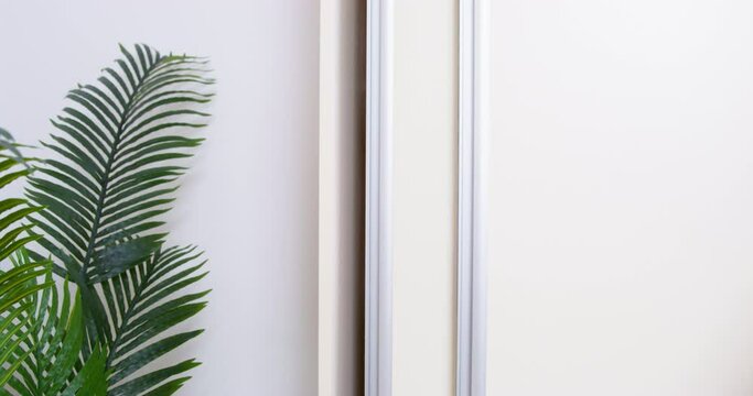 White wooden sliding door wardrobe is shaking because of an earthquake, or because someone has hidden there and is messing around inside, front view, close up