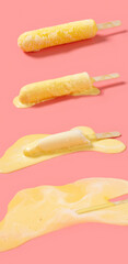 yellow milkshake flavor popsicle melting process on a pink background