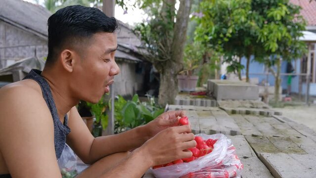 Surprised expression of a young man enjoying Rose apples