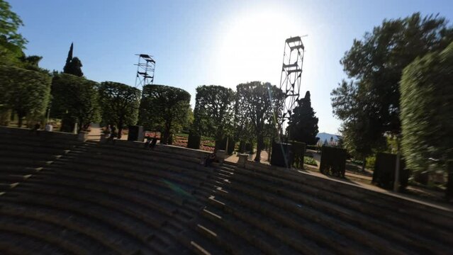 Dynamic fpv drone shot cruising around ancient amphitheater sunny day 