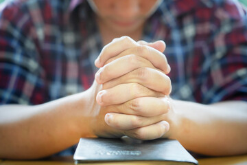 Christian Praying on open Bible.