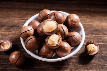Macadamia nuts in a plate on wooden table