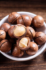 Macadamia nuts in a plate on wooden table