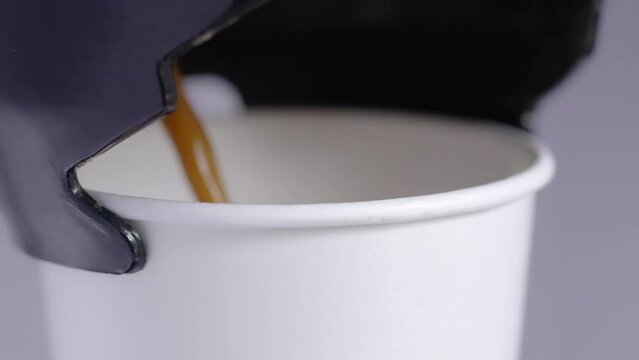 Automatic coffee machine with hot coffee white paper cup, Vending coffee machine pouring in a paper glass in morning drink, Close up slow motion and handhelds.