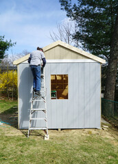 worker building the shed in the back yard