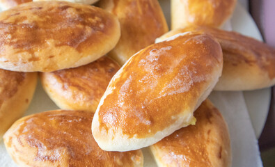 Lots of delicious freshly baked hot pies with stuffing, food background, close-up, Russian cuisine