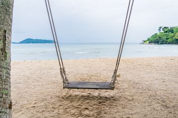Wood swing at the beach and sand background.