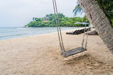 Wood swing at the beach and sand background.
