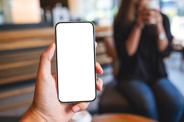 Mockup image of a man holding mobile phone with blank white screen with a woman in background