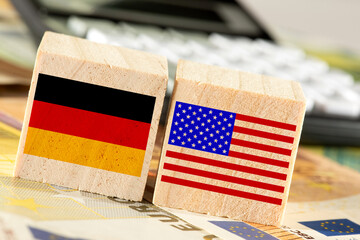 Flaggen vom Deutschland und USA, Euro Geldscheine und ein Taschenrechner