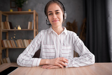 Portrait headshot screen view of smiling young hispanic woman in headphones look at camera and talk...