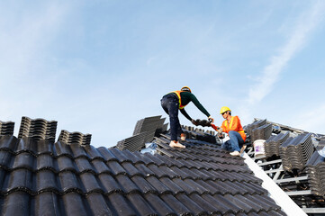 Builders in work clothes install new roofing tools, roofing tools, electric drill and use them on...