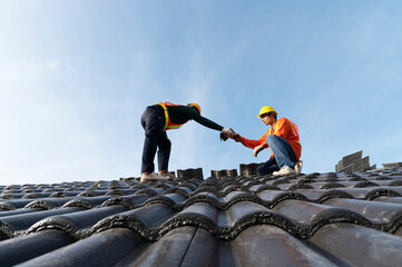 Builders in work clothes install new roofing tools, roofing tools, electric drill and use them on...