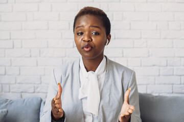 African American woman looking at camera, talking on video call, recording video at home. Business meeting. Business woman video conference. Corporate business