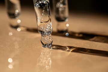 Three pipettes of cosmetic gel on a beige background.