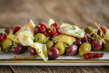 Plate of gourmet olives wine appetizer on wooden background