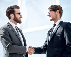 handshake business partners in a bright office