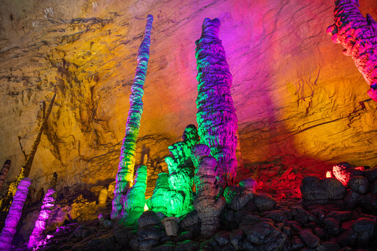 Close up vertical shot of the stalictites of the Huanglong cave in Zhangjiajie, Hunan, China. Purple, pink, green, orange colors