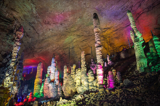 Horizontal shot of the Stalactites in Huanglong cave, horizontal background image with copy space for text, colorful lighting, blue, green, yellow and pink light