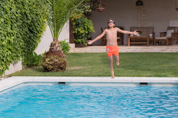 person relaxing in the pool. Blond boy with sunglasses diving into the pool