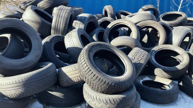 Used car tires stacked in a mess. A mountain of tires. Recycling of car waste.
