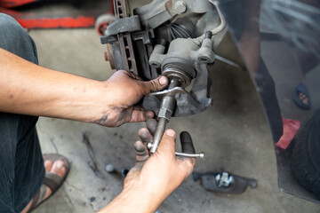 Vehicle's disc brake inspection and maintenance for repair. Car brake repair in garage. close-up photo