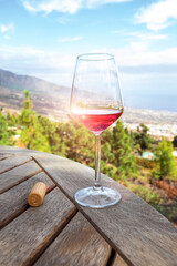 Rose wine glass and corkscrew of wooden table against the on vineyards land in the mountains with forest Exotic Hight altitude wine tasting experience