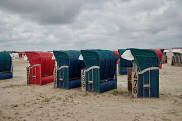 Obraz premium Verlassene Strandkörbe im niedersächsichen Bensersiel bei schlechtem Wetter