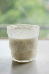 Pure milk in glass, naturally healthy foods placed on a white wooden table