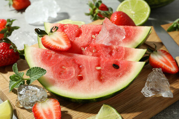 Fresh and juicy fruits with ice on gray textured background