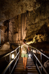 Mujer exploradora atravesando profundas cavernas y cuevas