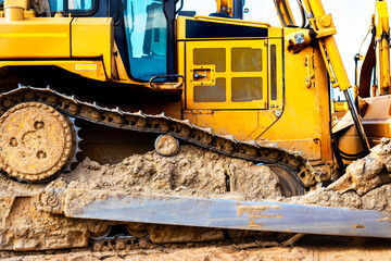 Bulldozer machine is leveling construction site. Earthmover with sky background. close-up. construction heavy machinery.