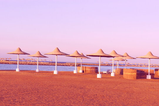 Sand beach umbrellas on the beach at sunset.