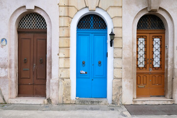 Obraz na płótnie Canvas Traditional vintage painted wooden door in Malta. Popular travel destination. Entrance to house. Exterior of typical houses on the Mediterranean island of Malta - April, 2022.