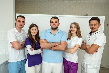 five energetic specialists in the field of medicine smile beautifully at their patients.