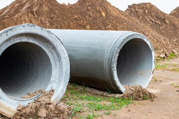Reinforced concrete storm sewer pipes of large diameter stacked at a construction site. Sewer Large...