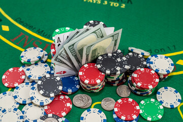 many colored chips of cards and dollars are scattered for poker.