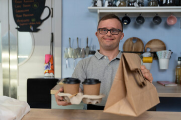 Caucasian man with down syndrome serving food to take away