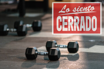 in Spanish inscription sorry we are closed. the closure of the gym during the lockdown. dumbbells...